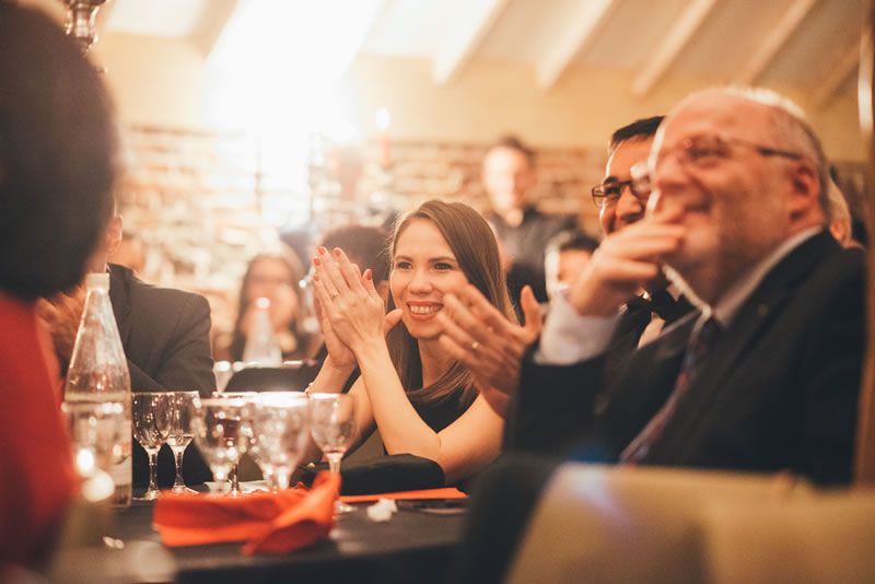 Applauding and laughing audiences enjoy Tony Price's magic show at their company party.