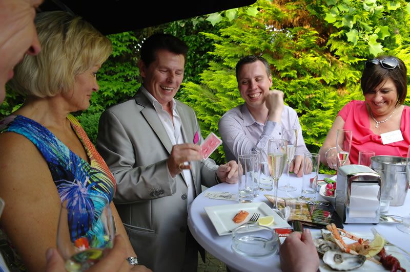 Guests laugh enthusiastically at the tricks and jokes of magician Tony Price.