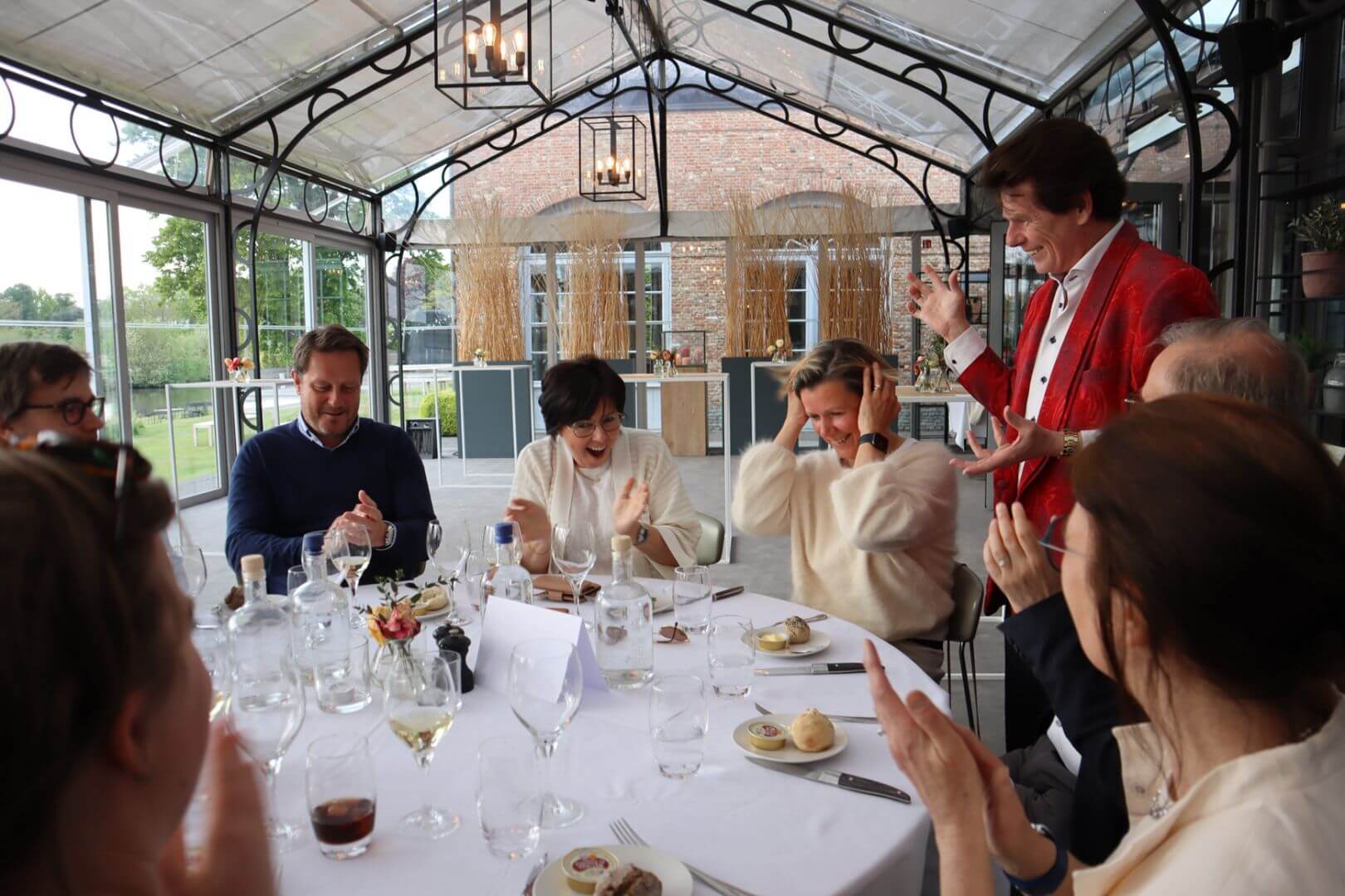 Public à table applaudit émerveillé et enthousiaste devant le magicien de close-up Tony Price.