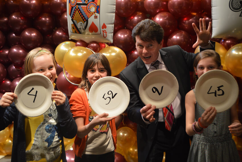 Children, holding cardboard plates in their hands, pose with Tony after the show.