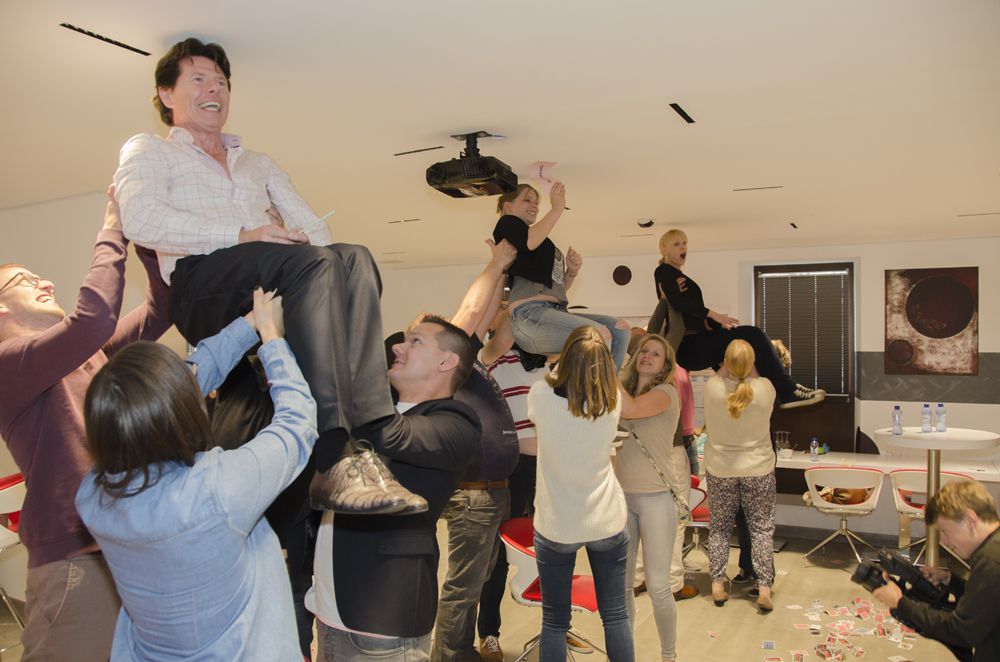 Participants lift someone into the air during the team building using the Carpenter effect.