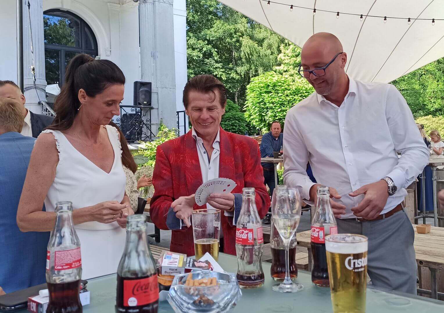 Wedding couple watches magician Tony Price in amusement as he performs a trick for them.